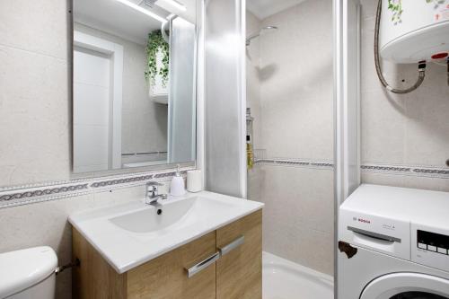 a bathroom with a sink and a toilet and a mirror at Calle Manuel Mena 4 in Benalmádena
