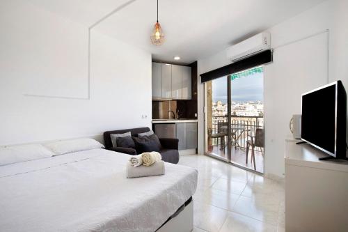 a white bedroom with a bed and a kitchen at Calle Manuel Mena 4 in Benalmádena