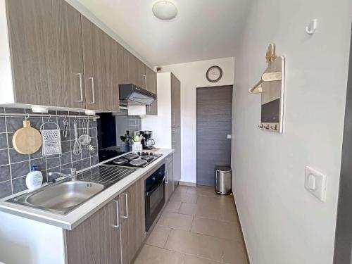 une petite cuisine avec un évier et une cuisinière dans l'établissement Studio 27m² proche mer avec balcon, parking et ascenseur - tout confort ! - FR-1-646-16, à Berck-sur-Mer