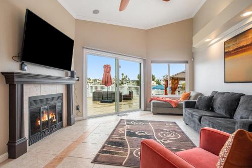 a living room with a fireplace and a flat screen tv at Lakefront Gem: Private Dock in Discovery Bay