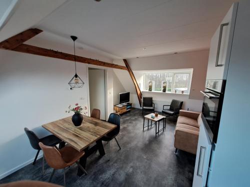 a living room with a wooden table and chairs at de Bloemenhof in Ouddorp