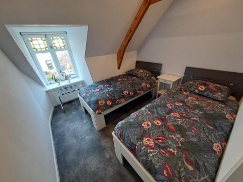 a bedroom with two beds and a window at de Bloemenhof in Ouddorp