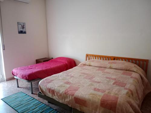 una camera con due letti con lenzuola rosa sopra di Villa di Pietro a Pescara