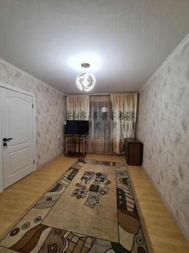 una sala de estar con una alfombra grande en el suelo en уютная квартира, en Shymkent