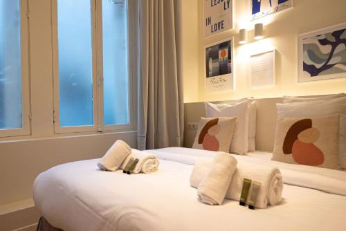 une chambre avec deux lits avec draps blancs et oreillers dans l'établissement Amazing flat in champs elysées., à Paris