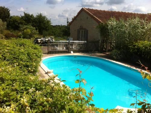 una piscina azul frente a una casa en La Petite Maison, en Crézières