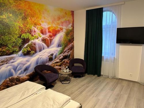 a bedroom with a painting of a waterfall at Weißes Haus in Plauen