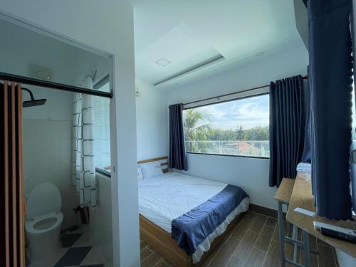 ein kleines Schlafzimmer mit einem Bett und einem Fenster in der Unterkunft Ngoc An Hotel in Tây Ninh