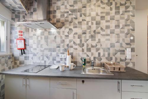 a kitchen with a sink and a tiled wall at Casa da Vila nº 6 in São Brás de Alportel