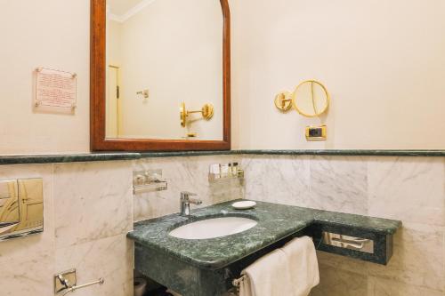 a bathroom with a sink and a mirror at Art Hotel Commercianti in Bologna