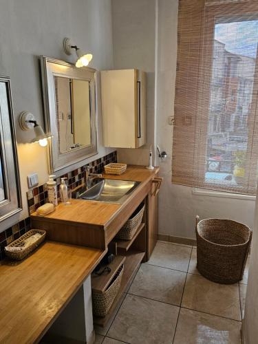 - une petite cuisine avec un évier et un miroir dans l'établissement Maison de maître dans le village, bord de mer, à Torreilles