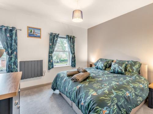 um quarto com uma cama, uma secretária e 2 janelas em Horseshoe Cottage em Skegness