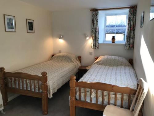 2 camas individuales en una habitación con ventana en Stable Cottage, Ardnadrochet en Lochdon