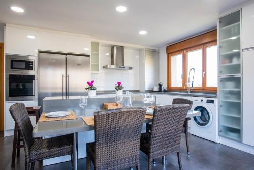 a kitchen with a table and chairs in a kitchen at Apartamentos Cangas Relax En Grupo in Cangas de Onís