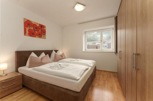 Un dormitorio con una cama grande y una ventana en Appartementhaus Crystal by Schladming-Appartements, en Schladming