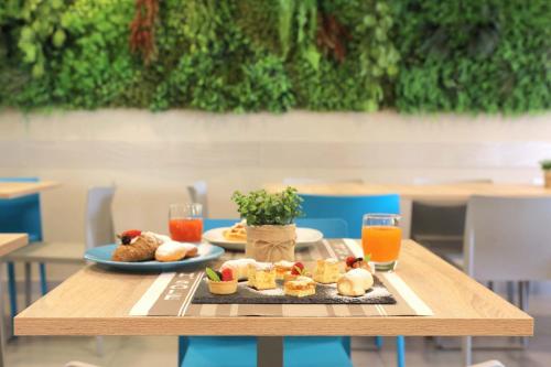 Hotel Sole في كاتوليكا: طاولة مع طبقين من الطعام وكأسين من عصير البرتقال