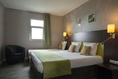 カルクフーにあるThe Originals City, Hotel Novella Premium, Nantes Estの大きなベッドと椅子が備わるホテルルームです。