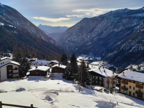a snow covered village with mountains in the background at Casa Lo Tzé Relais - Indipendent house with amazing view in Valtournenche