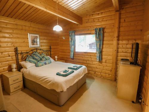 1 dormitorio con 1 cama en una cabaña de madera en Bamboo Retreat, en Legbourne