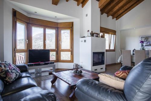 a living room with a leather couch and a table at Cangas Relax En Grupo in Cangas de Onís