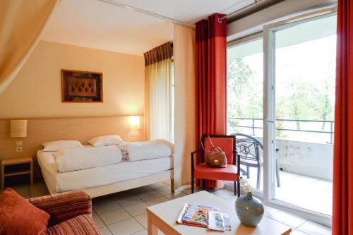um quarto de hotel com uma cama e uma grande janela em Adonis Divonne-Les-Bains Résidence Du Lac em Divonne-les-Bains