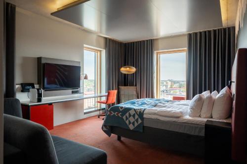 a hotel room with a bed and a flat screen tv at Solo Sokos Hotel Torni Tampere in Tampere