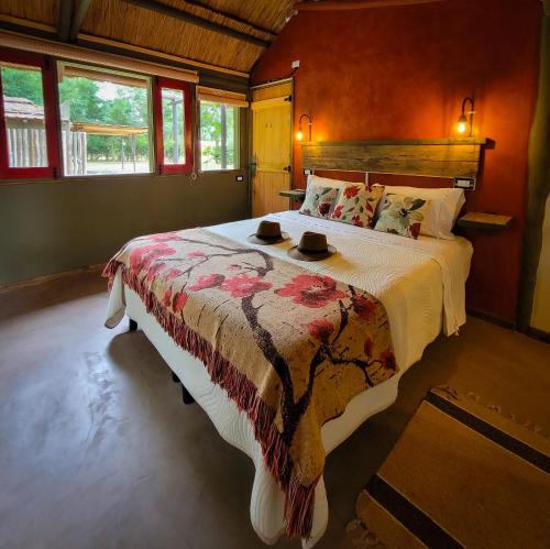 um quarto com uma cama grande com dois chapéus em La Saucina - Cabaña Rústica Chic em Tunuyán