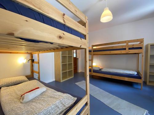 Ce lit se trouve dans un dortoir doté de 2 lits superposés et de sols bleus. dans l'établissement Da Silva Surfcamp 4 Bettzimmer mit Frühstück, à Lourinhã