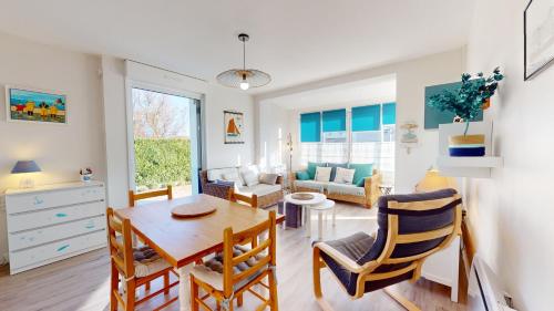 une cuisine et un salon avec une table et des chaises dans l'établissement La Mer a vos Pied pour 4 personnes, à Les Bussolleries