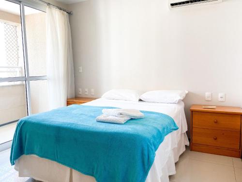 a bedroom with a bed with two towels on it at Condomínio Zaragoza no Parque Del Sol in Fortaleza