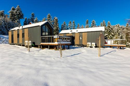 a couple of buildings sitting in the snow at Domki Piwniczna in Piwniczna