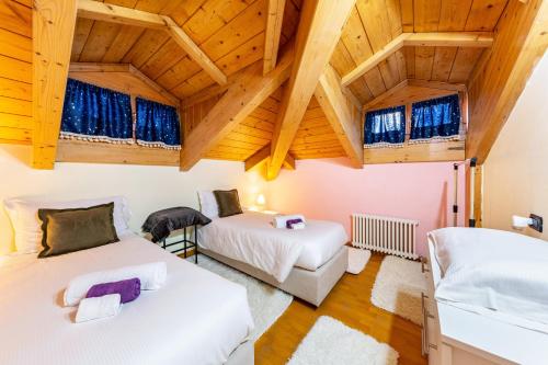 Casa Felice Venas في Venas: سريرين في غرفة بسقوف خشبية