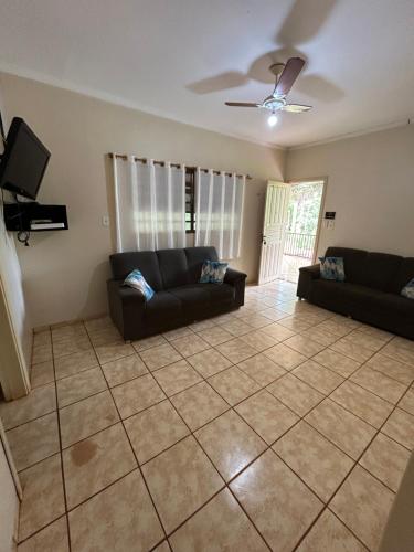 a living room with two couches and a tv at Casa aconchegante próximo ao Rio Dourados in Dourados