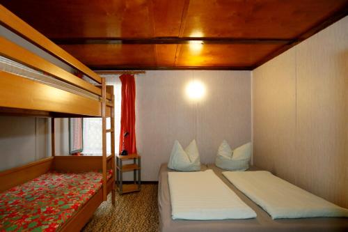 1 dormitorio con 2 camas y 1 litera en Bungalow MEER ODER WENIGER direkt am Strand en Dranske