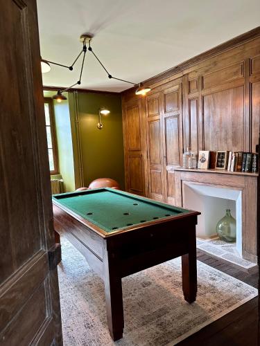 a room with a pool table and a fireplace at Le Château de Saint-Angel, Le Manoir du Rigouneix, 5 minutes A89, nature, calme, sauna in Saint-Angel