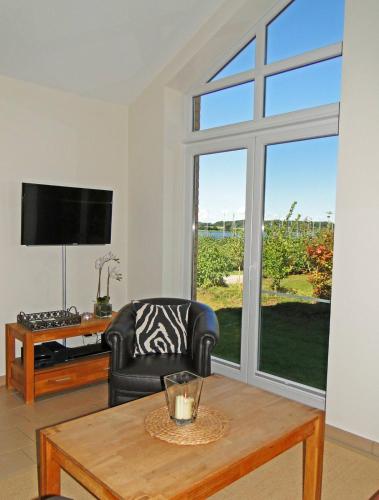 a living room with a chair and a table and a window at Leuchtturm in Bohnert