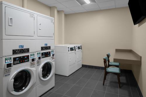 a laundry room with a washing machine and a chair at Hyatt House Lansing-University Area in Lansing