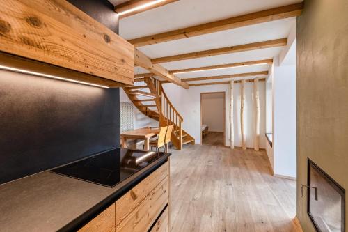 a kitchen with wooden floors and a staircase in a room at Naturoase Stegerhof Apt Ringelblume in Trodena