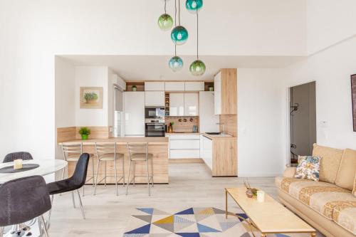 un salon et une cuisine avec un canapé et une table dans l'établissement Le Majestic by Plaza - Proche Disneyland Paris, à Chessy