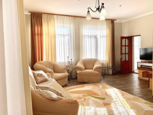 uma sala de estar com duas cadeiras e uma televisão em Hotel Europa em Truskavets