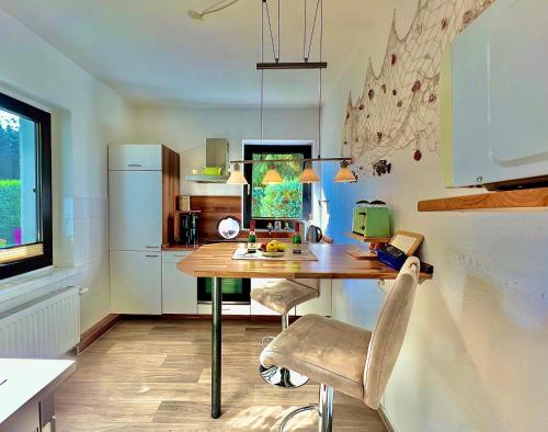 a kitchen with a table and chairs and a refrigerator at Haus am Berg 2 in Neuenkirchen