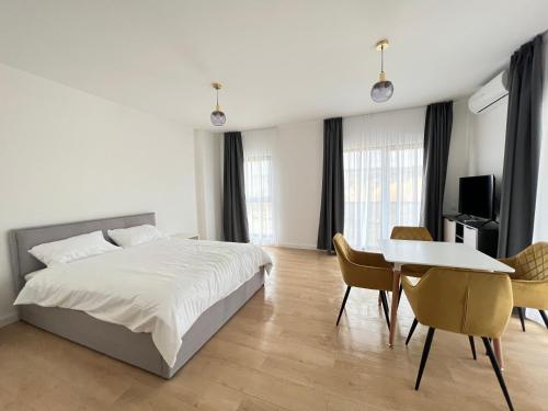 1 dormitorio con 1 cama, mesa y sillas en Exit Aparthotel, en Floreşti