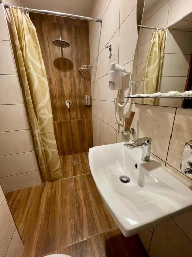 a bathroom with a sink and a shower at Sport Hotel 1 in Cherkasy