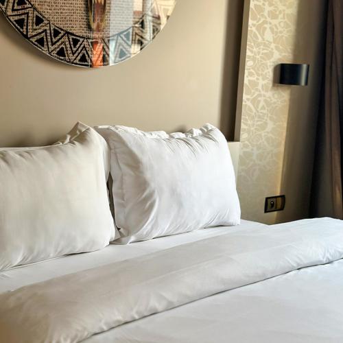 a bed with white pillows on top of it at Hotel Appartement Tanger in Tangier
