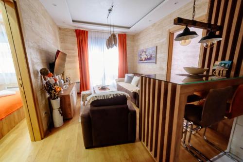uma sala de estar com uma cozinha com um sofá e uma mesa em Zlatibor Vila Peković Green S4 em Zlatibor