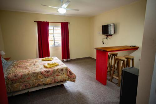 a bedroom with a bed and a table and a bar at Hotel Complejo Del Carmen San Bernardo in San Bernardo