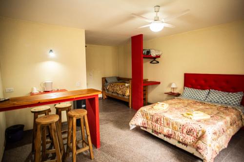 1 dormitorio con cama, mesa y taburetes en Hotel Complejo Del Carmen San Bernardo en San Bernardo