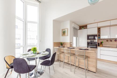 une cuisine et une salle à manger avec une table et des chaises dans l'établissement Le Majestic by Plaza - Proche Disneyland Paris, à Chessy