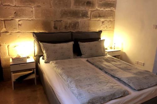 un letto in una stanza con due comodini di Luxury House of Character Golden Bay/Manikata. a Ix-Xagħra l-Ħamra