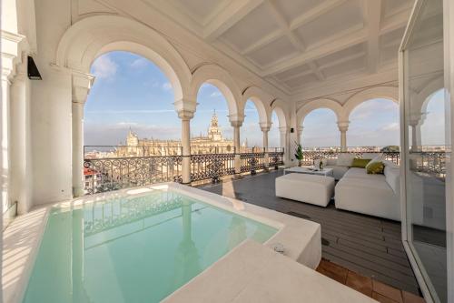 - une piscine dans un bâtiment avec vue sur la ville dans l'établissement The most Exclusive apartment in Sevillaparking, à Séville